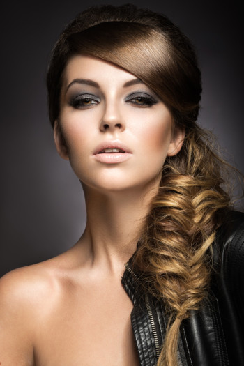 Beautiful girl with bright make-up, perfect skin and hairstyle as a braid.Picture taken in the studio on a gray background Beautiful girl with bright make-up, perfect skin and hairstyle as a braid.Picture taken in the studio on a gray background
